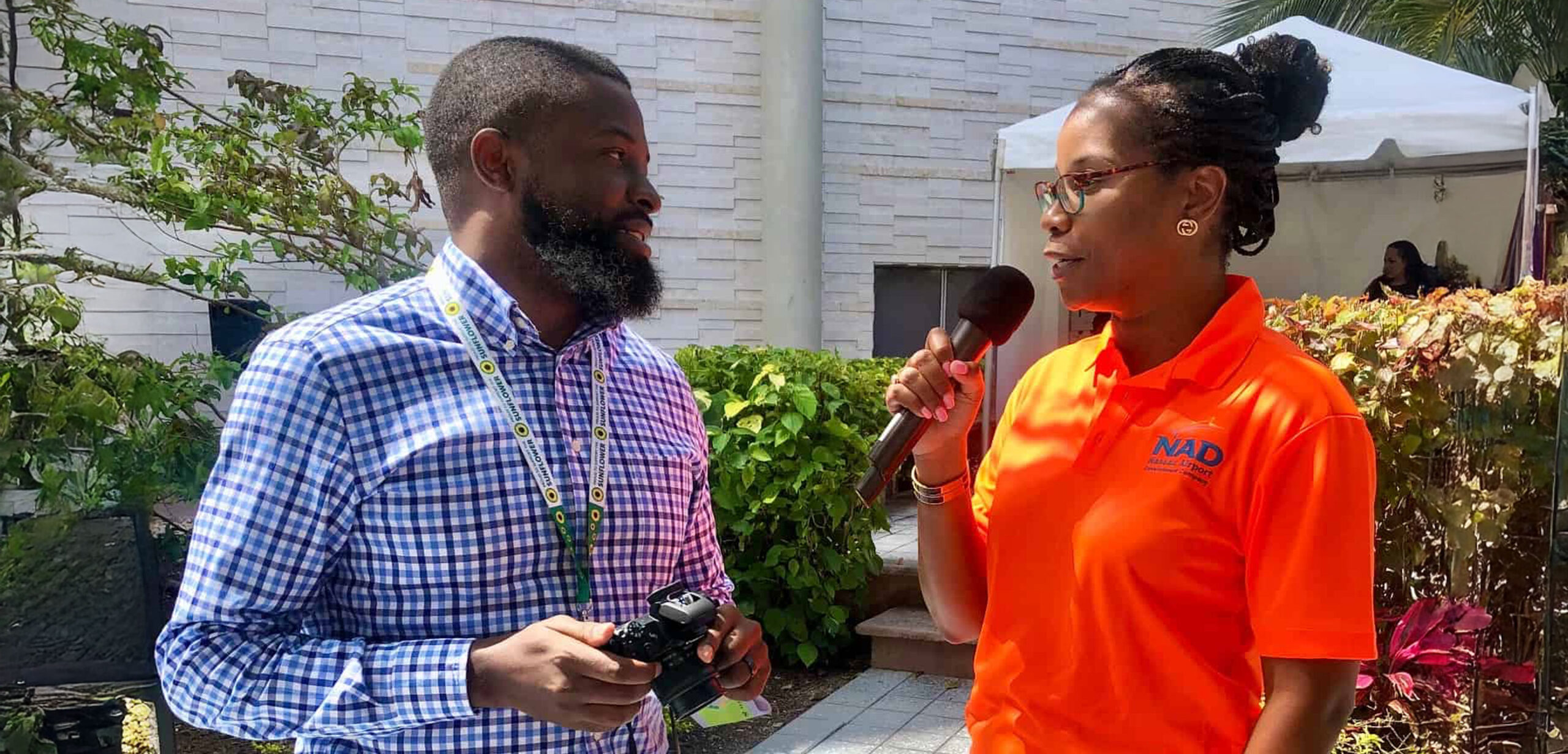 NAD representative speaking to a Sunflower Representative holding a camera.