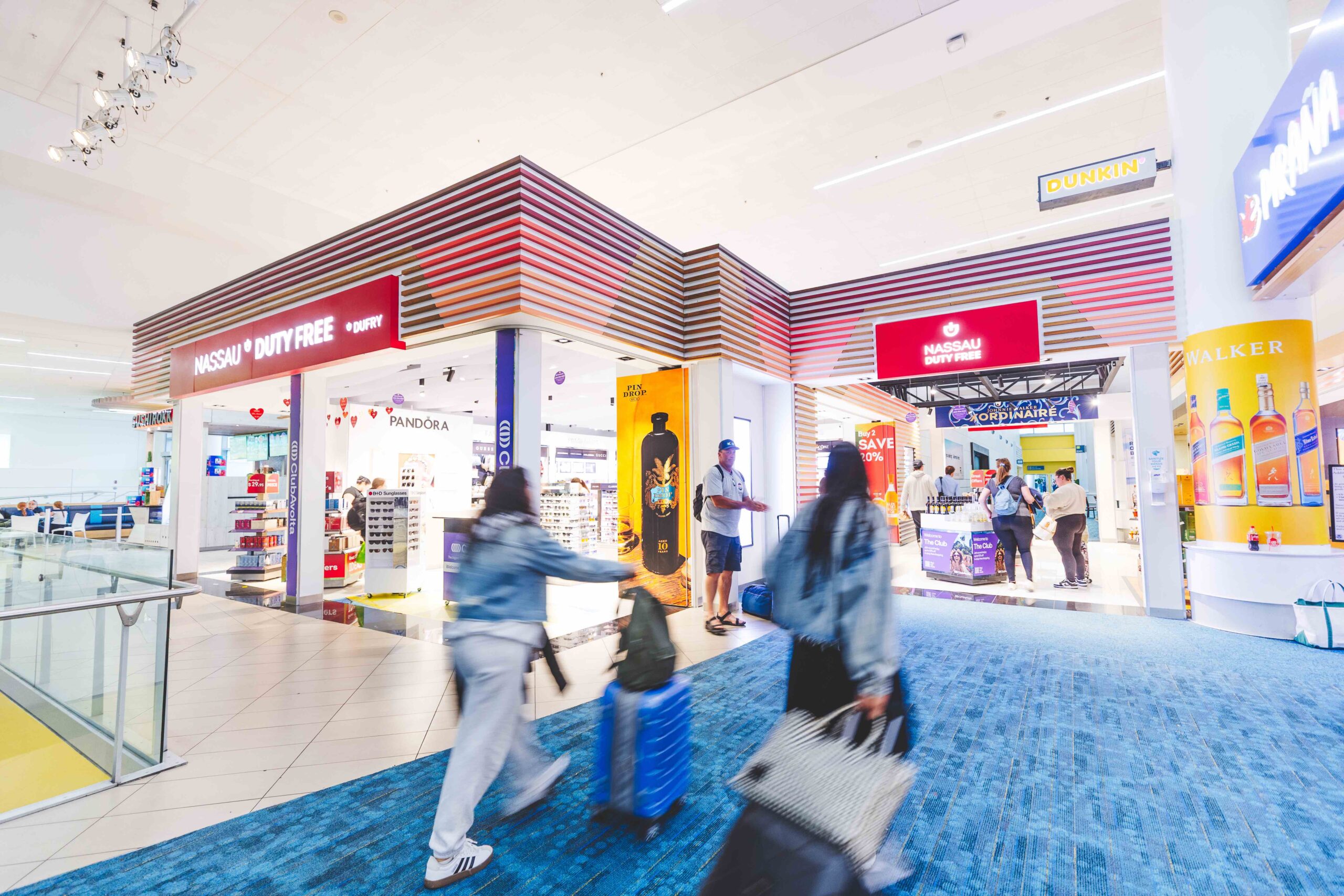 People walking through the duty free section of the airport.